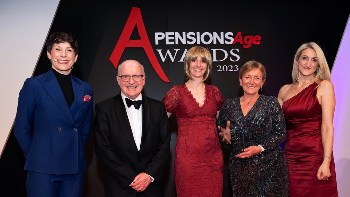 Five people stand together, smiling at an award ceremony, with one holding a trophy. A backdrop features the text "Pensions Age Awards 2023" prominently displayed.