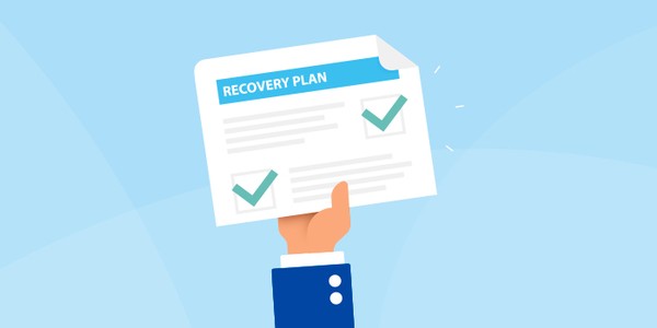 A hand is holding a document titled "RECOVERY PLAN," displaying checkmarks beside written points, set against a soft blue background. The hand is dressed in a blue suit.