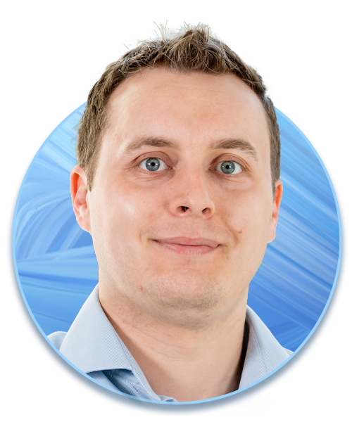 A man with short brown hair and light skin is smiling, facing forward. He wears a light blue shirt and is framed by a circular border against a soft blue abstract background.