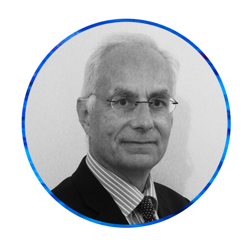 A man with silver hair and glasses wears a suit with a striped shirt and a polka dot tie, set against a blue abstract background. The image is circular in shape.