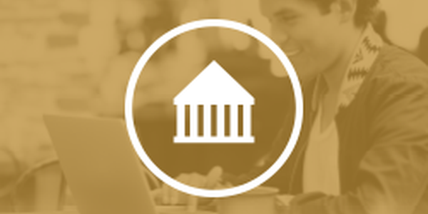 A person is smiling while working on a laptop in a cozy, softly lit environment. A coffee cup sits beside them, with an icon of a building in the foreground.