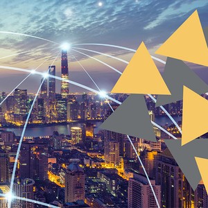 A vibrant cityscape features towering skyscrapers illuminated against a twilight sky, with abstract triangular shapes overlaying the scene, suggesting a connection to technology or data.