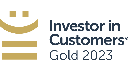 A logo features a stylized gold smiley face above the text “Investor in Customers® Gold 2023,” indicating recognition or achievement in customer investment for the year 2023.