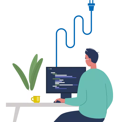 A person with short hair and glasses sits at a desk, typing on a computer with code displayed on the screen, surrounded by a plant and a cup, with an electrical cord above.