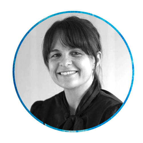 A woman with dark hair smiles, wearing a black blouse with a bow tie. The background features a vibrant blue texture, creating a contrasting visual environment.