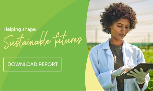 A woman in a lab coat and gloves uses a tablet while standing in a greenhouse surrounded by greenery. Text reads: "Helping shape Sustainable futures" and "DOWNLOAD REPORT."