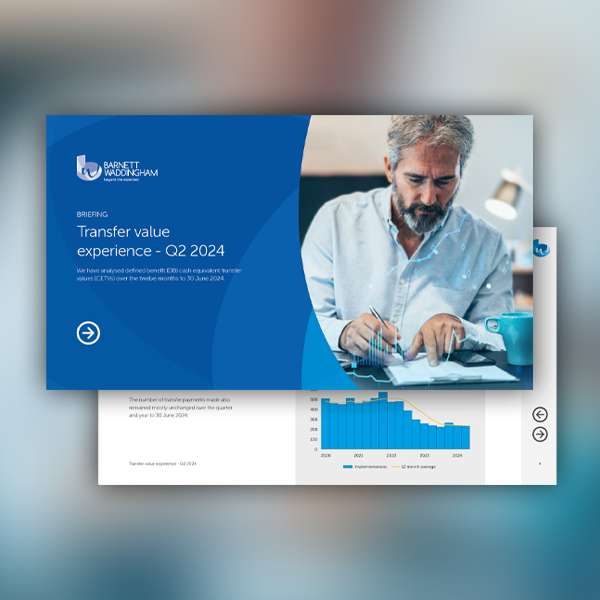 A man with a beard is writing notes on a document while reviewing a presentation slide titled "Transfer value experience - Q2 2024" in a professional office environment.