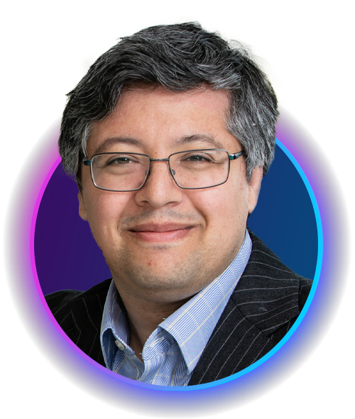 A man with glasses and short hair smiles in a circular frame. He wears a striped suit and blue shirt, with a gradient background transitioning from purple to blue.