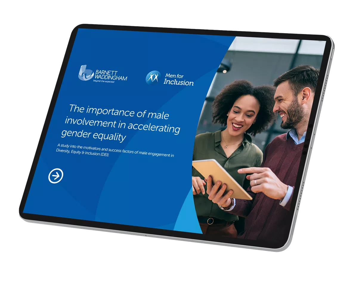 A tablet displays a presentation titled "The importance of male involvement in accelerating gender equality." Two people interact, smiling and discussing content in a modern indoor setting.