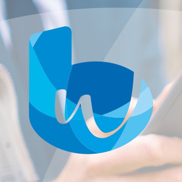 A person holds a smartphone while dressed in business attire, standing outdoors with a blurred background. A blue logo featuring stylized letters is prominently displayed in the foreground.