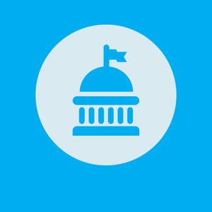 A blue and gray circular icon features a dome-shaped building with a flag atop it, symbolizing a government or legislative structure, set against a bright blue background.