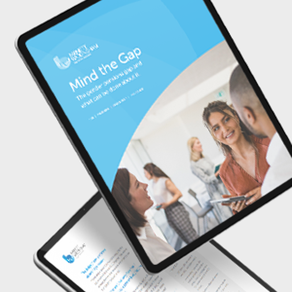 A digital tablet displays a document titled "Mind the Gap" in a professional setting. Two women engage in conversation while others are visible in the background, creating a collaborative atmosphere.